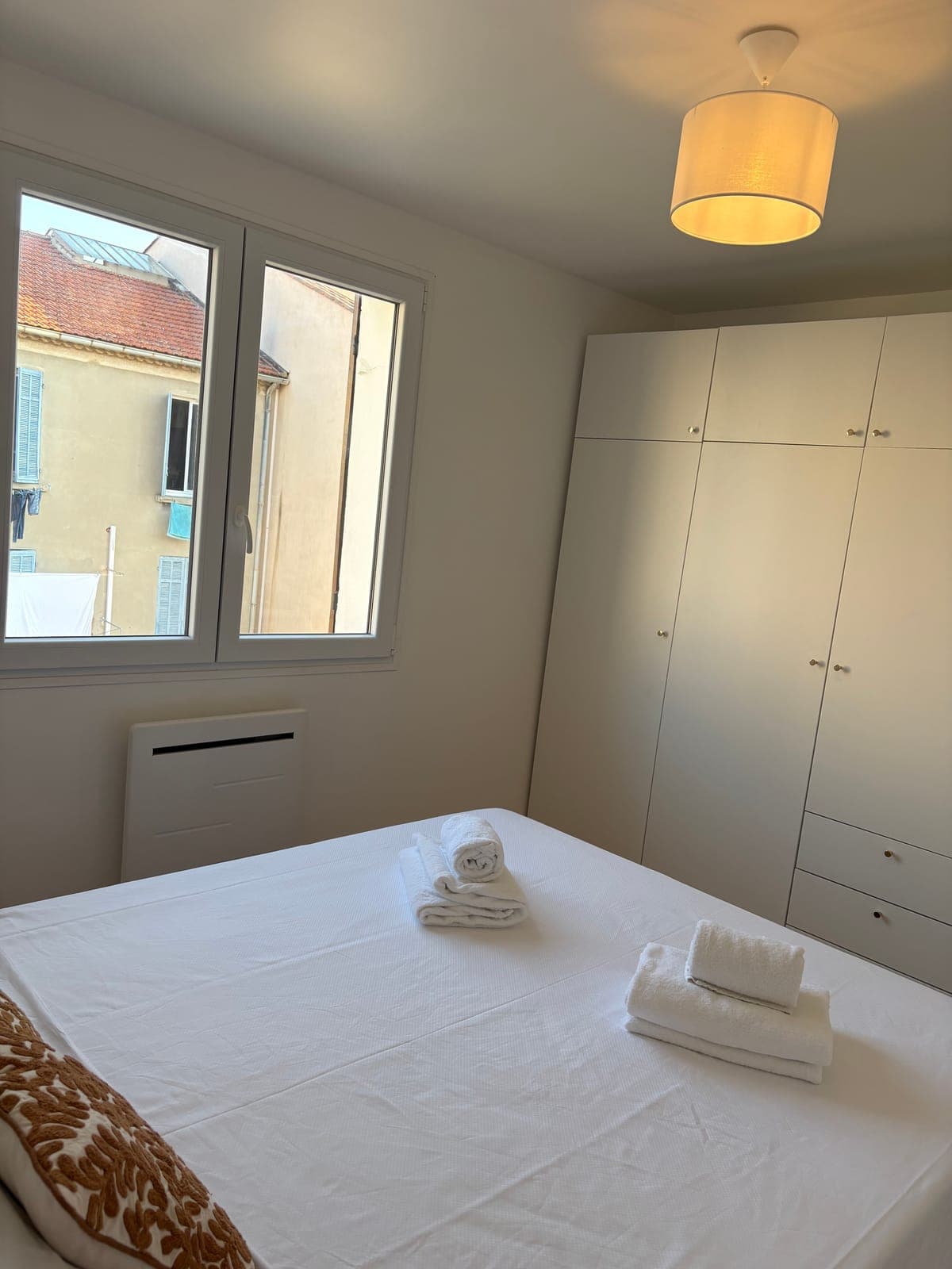 Soft wardrobes and late-afternoon light in the second bedroom — Sanary-sur-Mer — two apartment furnishing project