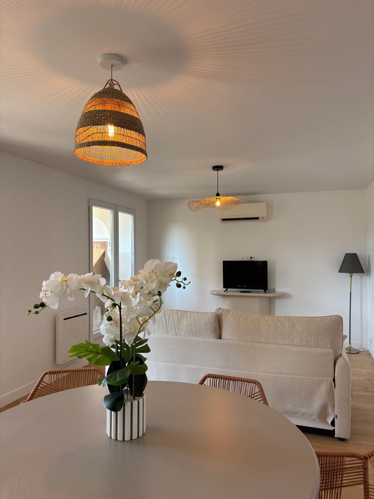 The open living area: dining, sofa and kitchen sharing the same light — Sanary-sur-Mer — two apartment furnishing project